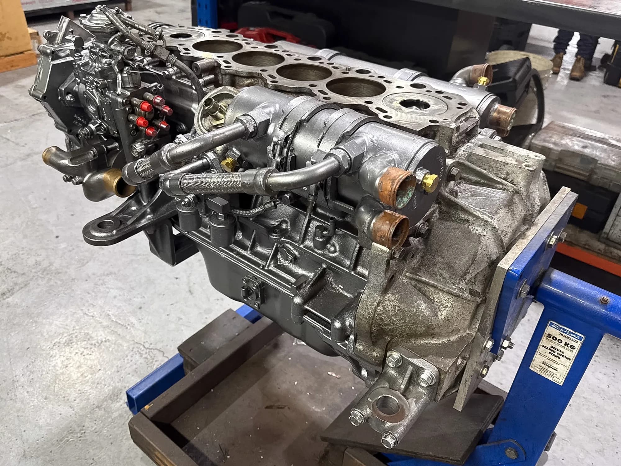 A six-cylinder Yanmar engine block with its fuel injection pump, mounted on a geared engine stand during a rebuild