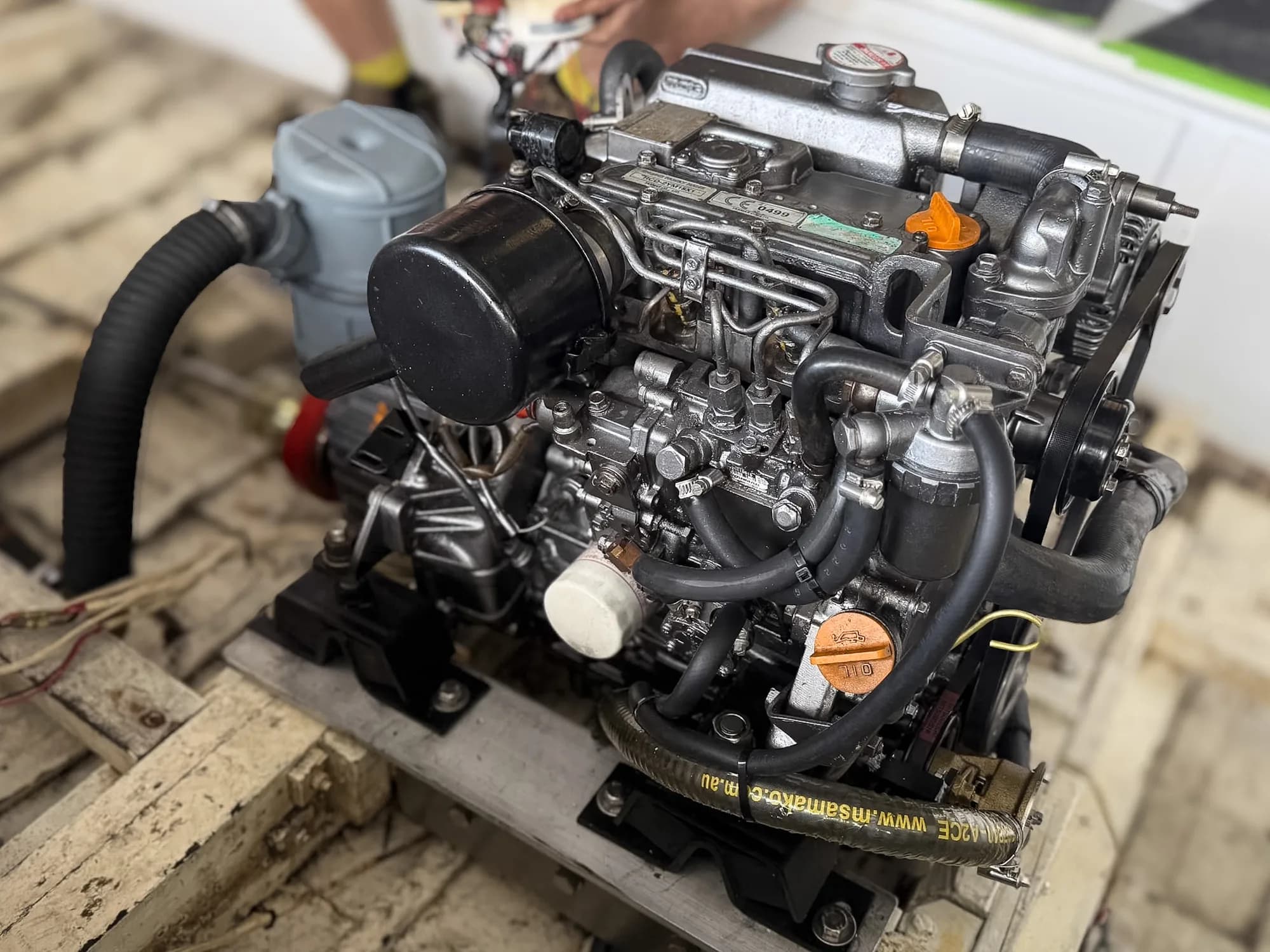 A small Yanmar marine diesel mounted on a pallet in the Sydney Diesel Marine workshop